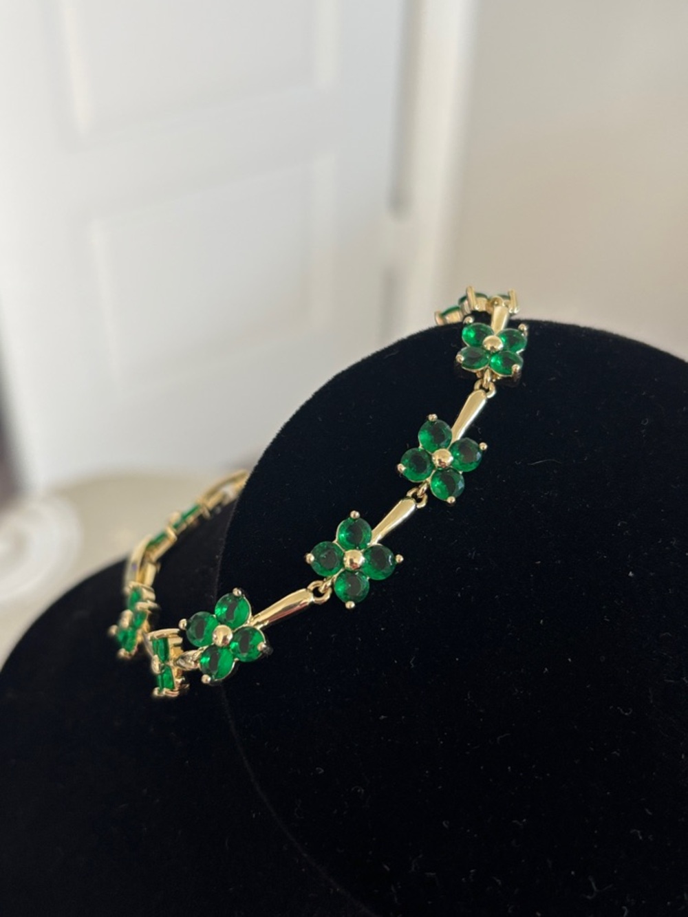 Gold tone Bracelet with emerald color stones.